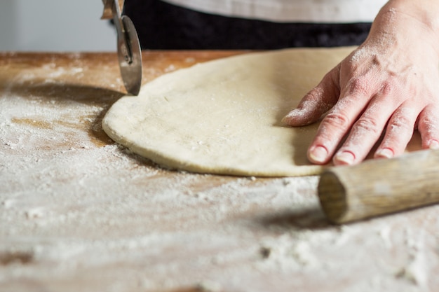 Vrouw die deegwaren van deeg maakt