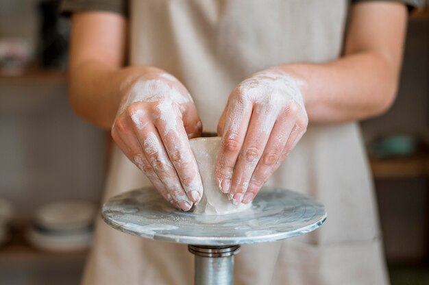 Vrouw die een aarden pot in haar atelier maakt