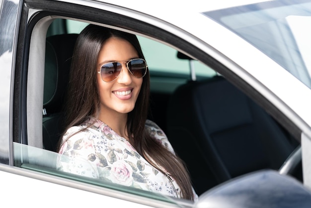 Vrouw die een auto bestuurt en glimlacht