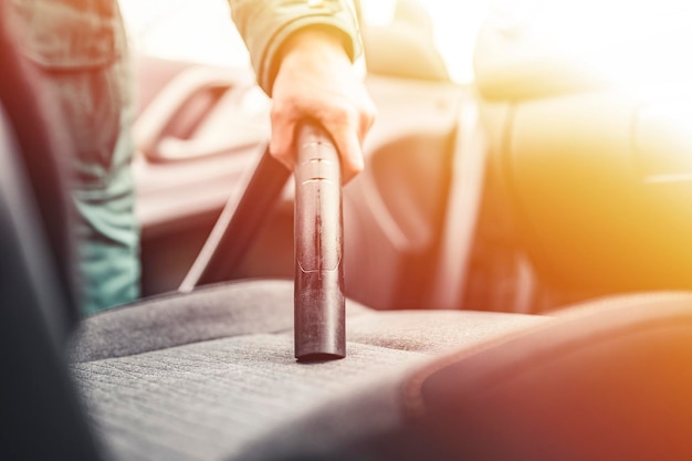 Vrouw die een autocabine stofzuigt Autostoelen interieurxA stofzuigen