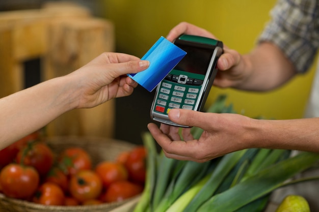 Vrouw die een betaling doet met behulp van Nfc-technologie in de supermarkt