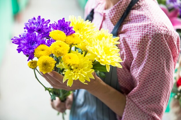 Vrouw die een boeket van bloemen in haar handen houdt