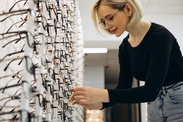 Foto vrouw die een bril kiest bij optiekwinkel