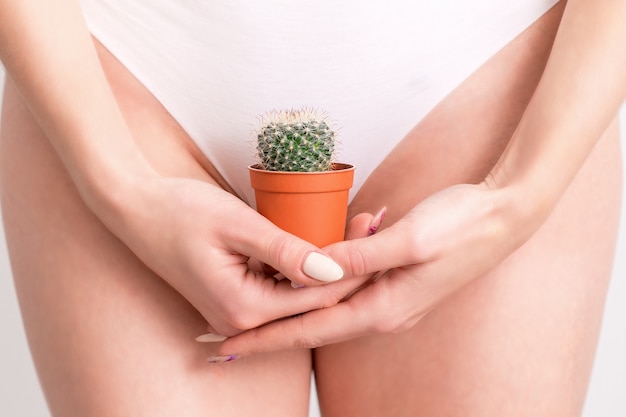 Vrouw die een cactus in een pot houdt.