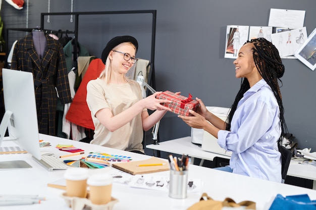 Vrouw die een cadeau geeft aan haar collega