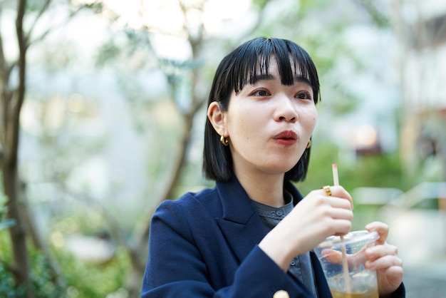 Vrouw die een drankje drinkt op straat