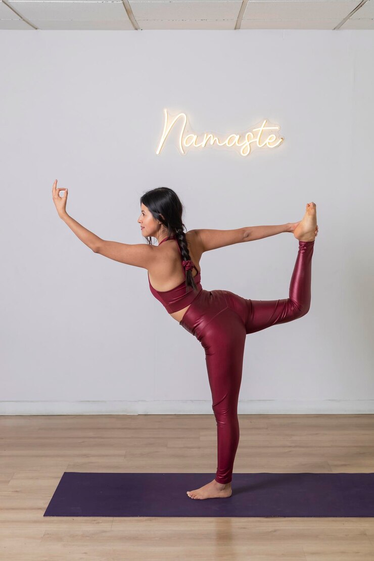 Vrouw die een evenwichtshouding inneemt tijdens het beoefenen van yoga in een studio tuladandasana