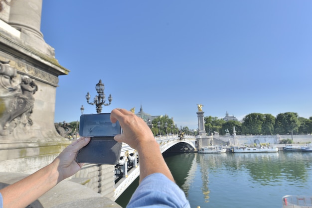 Vrouw die een foto met een smartphone in Parijs neemt