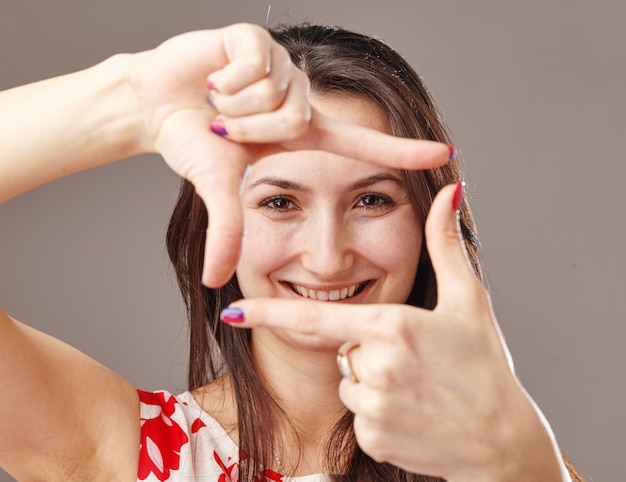 Vrouw die een frame maakt met behulp van handen