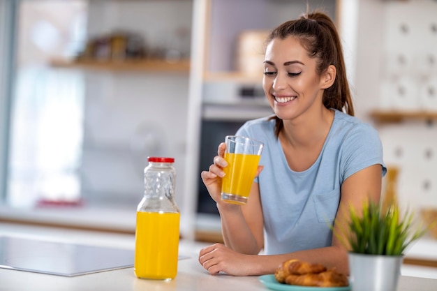 Vrouw die een glas verse jus d'orange drinkt