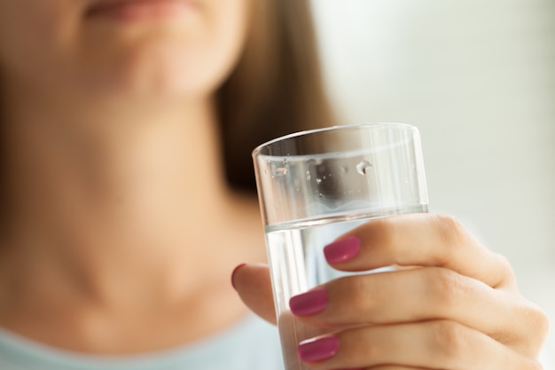 Vrouw die een glas water, close-up houdt