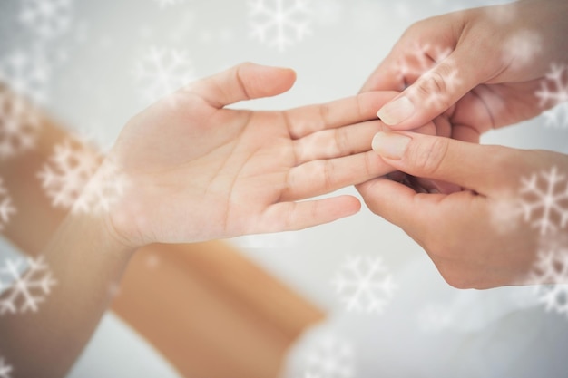 Vrouw die een handmassage krijgt tegen sneeuwvlokken