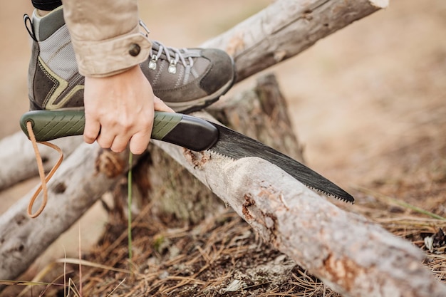 Vrouw die een hout snijdt met een handzaag