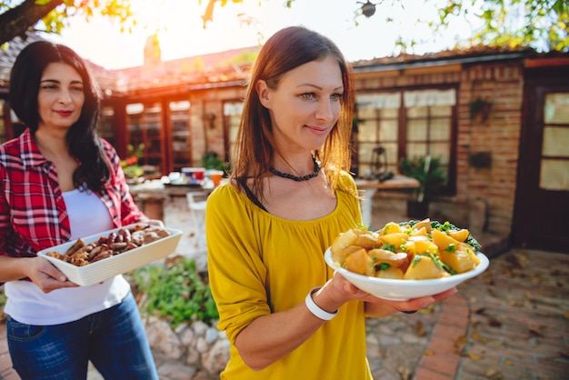 Vrouw die een kom met geroosterde aardappels draagt