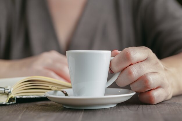 Vrouw die een kop hete koffie drinkt