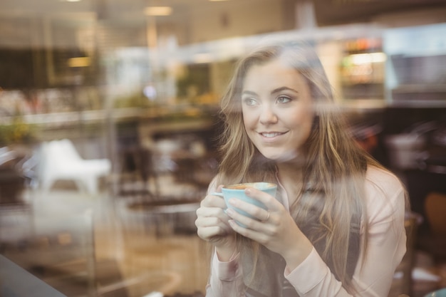 Vrouw die een kop van koffie drinkt