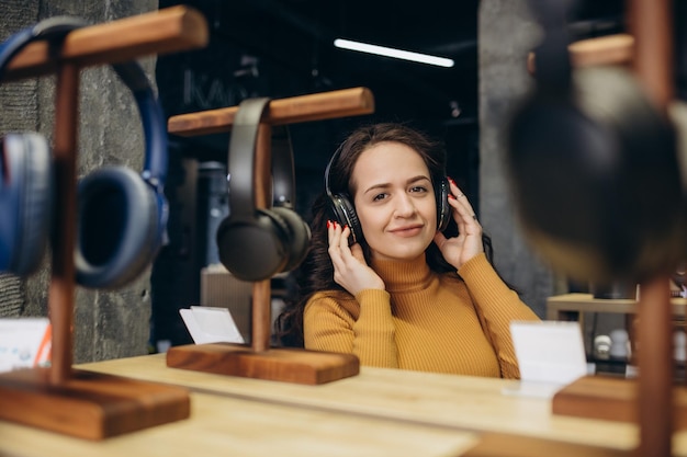 Vrouw die een koptelefoon probeert in een akoestiekwinkel