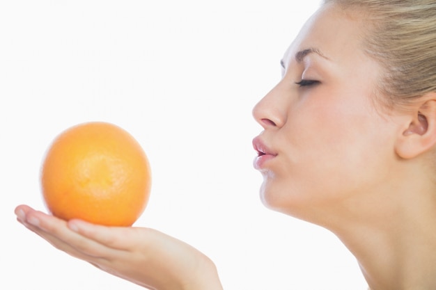 Vrouw die een kus blaast aan sinaasappel