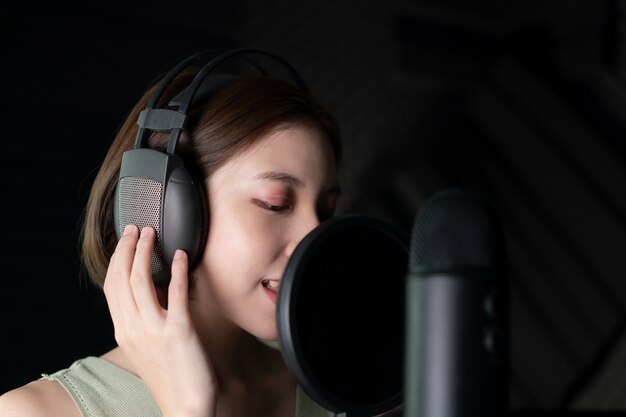 Vrouw die een lied opnemen of verhalen vertellen in de studio