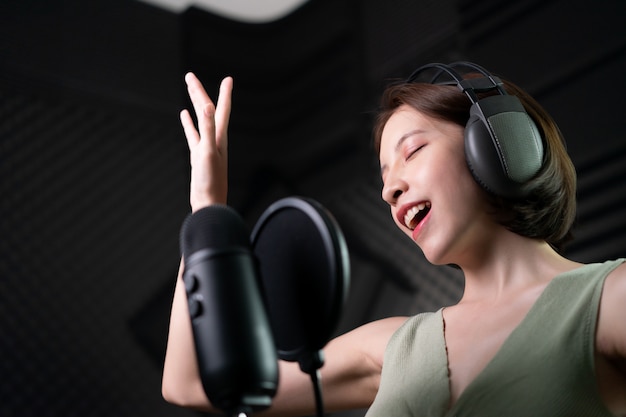 Vrouw die een liedje of verhalen opneemt in de studio.