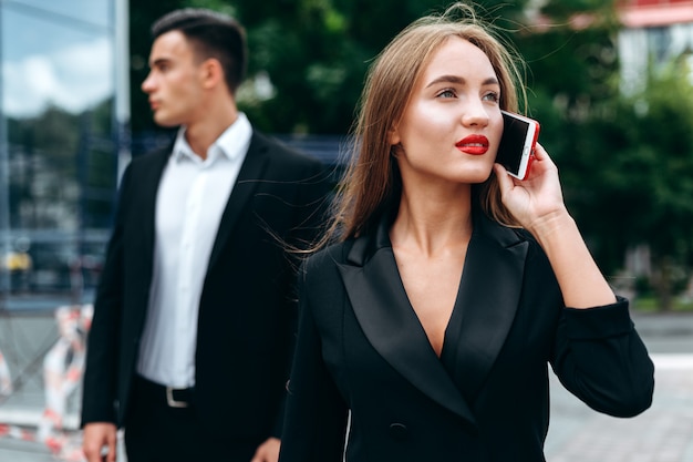 Vrouw die een mobiele telefoon spreekt. Man in zachte focus - afbeelding