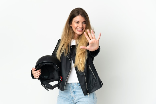 Vrouw die een motorhelm houdt die op witte muur wordt geïsoleerd die vijf met vingers telt