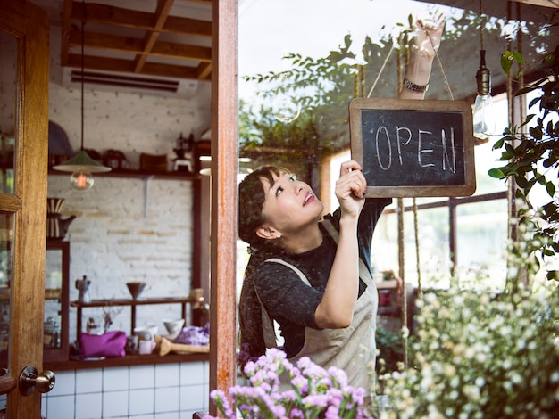 Vrouw die een open teken hangt