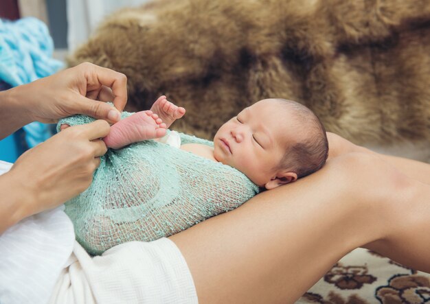 Vrouw die een pasgeboren baby op haar benen houdt