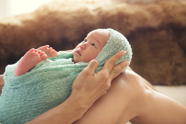 Vrouw die een pasgeboren baby op haar benen houdt