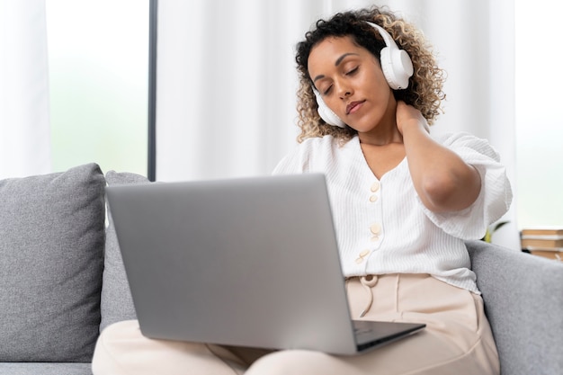 Foto vrouw die een pauze neemt terwijl ze thuis naar muziek luistert