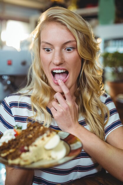 Foto vrouw die een plaat van desserts houdt