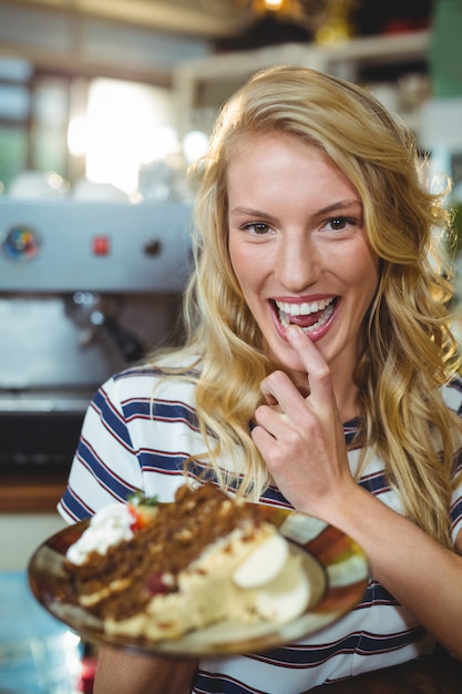 Foto vrouw die een plaat van desserts houdt