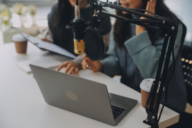 Foto vrouw die een podcast opneemt op haar laptop met een koptelefoon en een microscoop vrouwelijke podcaster die een audio podcast maakt vanuit haar thuisstudio