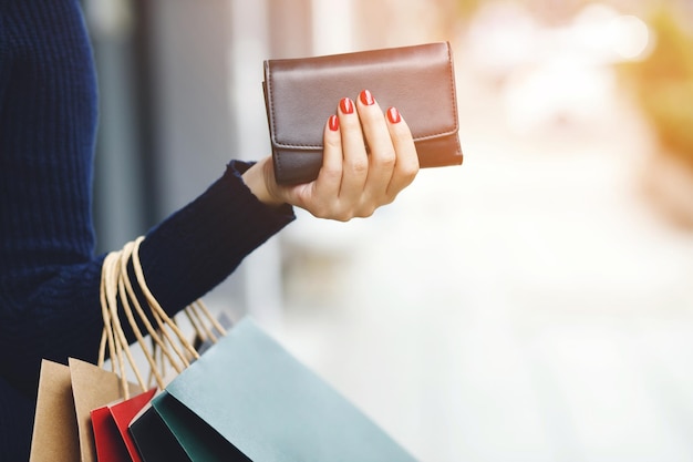 Vrouw die een portemonnee in de hand houdt Kostenbeheersing uitgaven winkelen in concept Laat ruimte over om beschrijvende tekst te schrijven