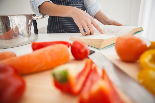 Vrouw die een recept in boek volgt