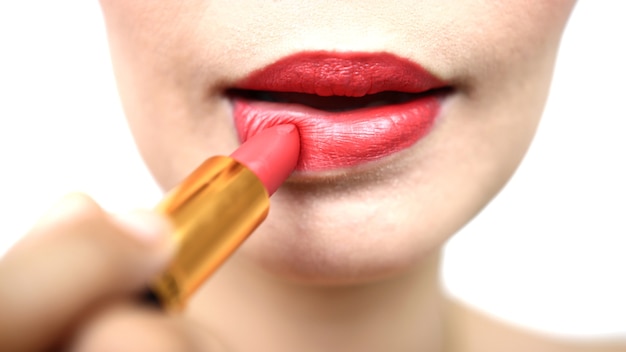 Vrouw die een rode lippenstift schildert