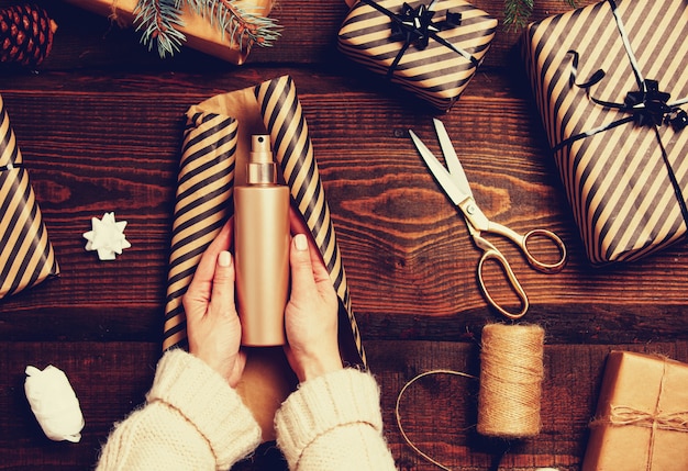 Vrouw die een roomfles inpakt als Kerstmisgift