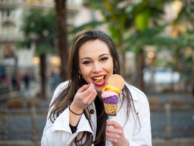 Vrouw die een roomijskegel eet openlucht