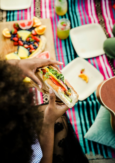 Vrouw die een sandwich eet bij het strand