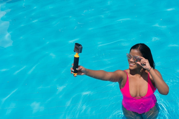 Vrouw die een selfie maakt met een actiecamera in een zwembad