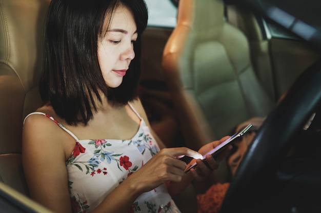 Vrouw die een smartphone in de auto gebruiken