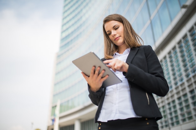 Vrouw die een tablet voor haar bureau gebruikt