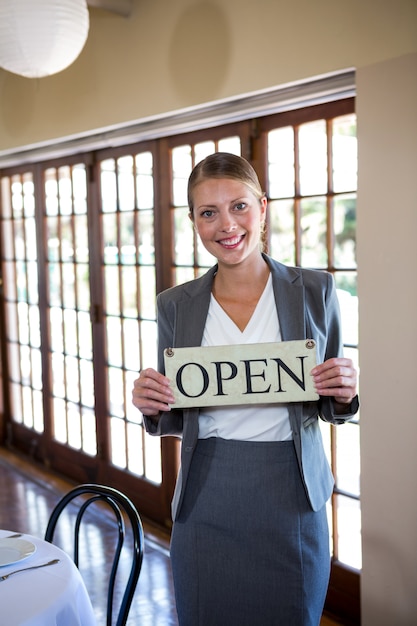 Vrouw die een teken met open houdt