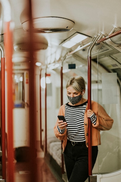 Vrouw die een telefoon gebruikt in een trein in het nieuwe normaal