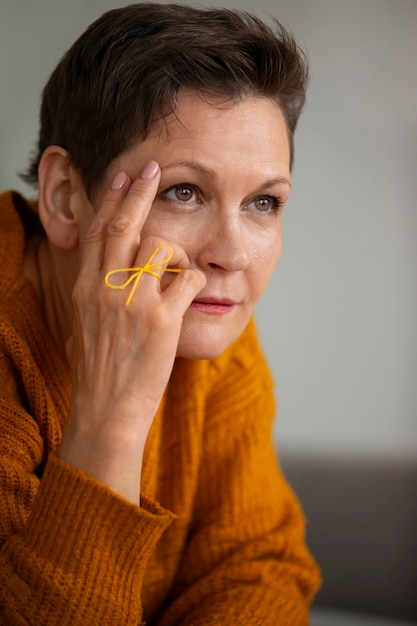 Foto vrouw die een touwtje aan de vinger draagt ter herinnering