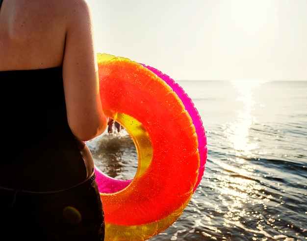 Vrouw die een zwemmende ring draagt ​​aan het strand