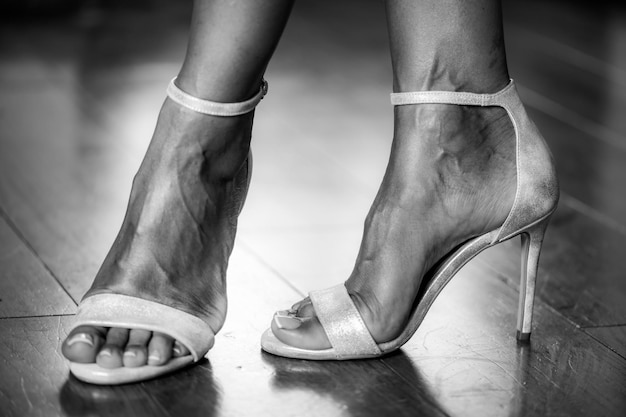 Foto vrouw die elegante zilveren sandalen aantrekt