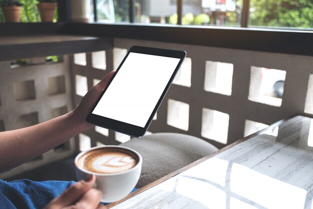 Vrouw die en een zwarte tablet houdt bekijkt