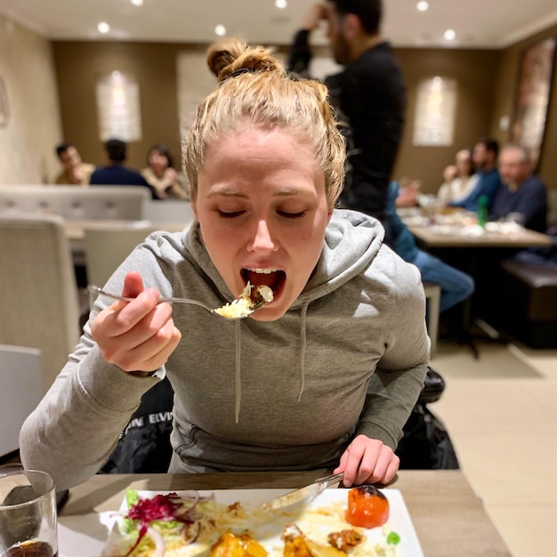 Vrouw die eten eet in een restaurant