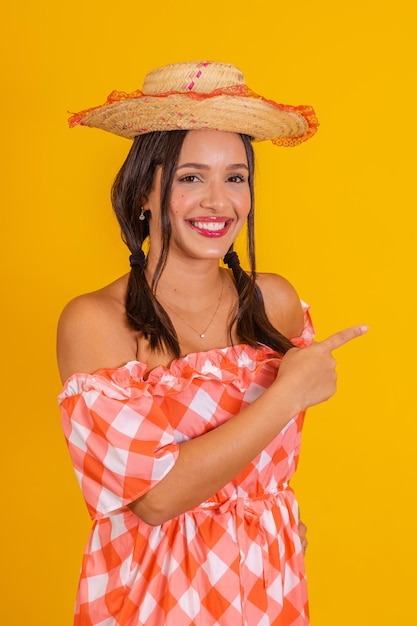 Vrouw die festa junina-kleding draagt, typisch Braziliaans feest dat naar de zijkant wijst, gratis voor tekst